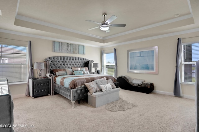 bedroom with a raised ceiling, ornamental molding, and carpet flooring