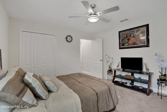 bedroom featuring ceiling fan, light carpet, and a closet