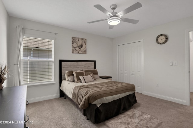 carpeted bedroom featuring ceiling fan and a closet