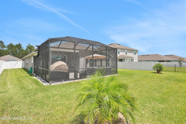 rear view of house featuring a lanai and a yard