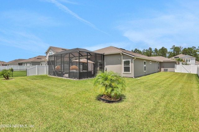 back of property featuring a lanai and a lawn