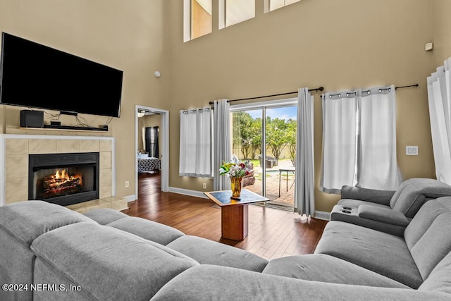 living room featuring a tiled fireplace and hardwood / wood-style flooring