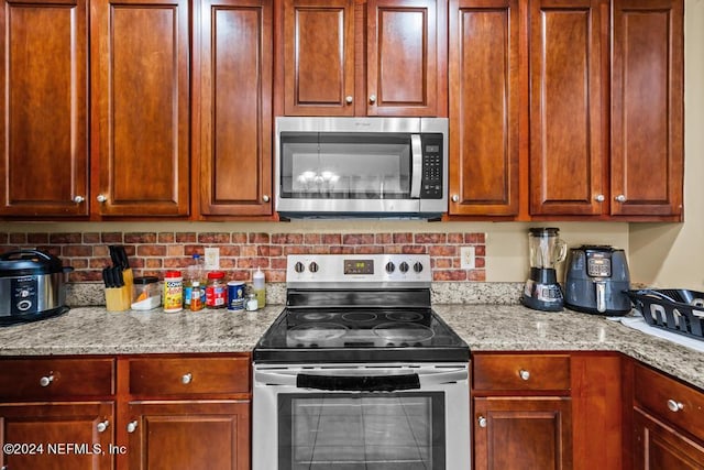 kitchen featuring light stone counters and appliances with stainless steel finishes