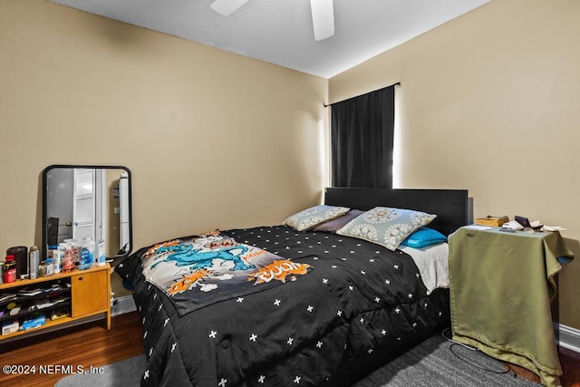 bedroom with dark hardwood / wood-style flooring and ceiling fan