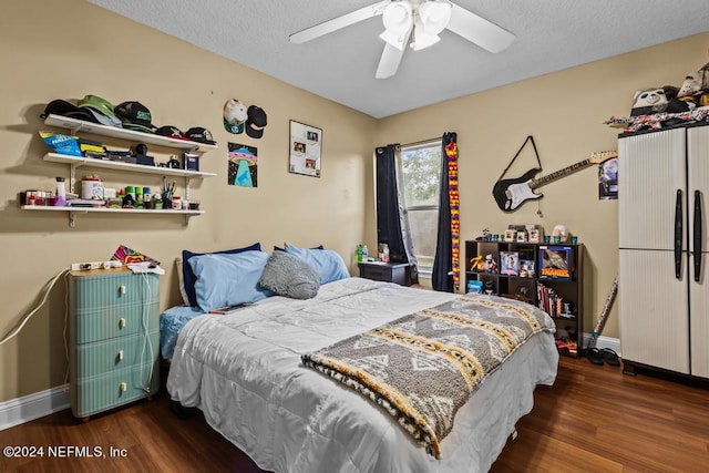 bedroom featuring a textured ceiling, dark wood-type flooring, and ceiling fan