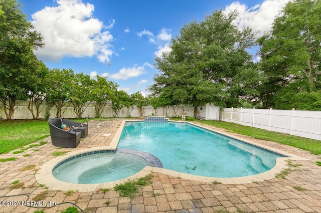 view of swimming pool featuring an in ground hot tub and a patio area