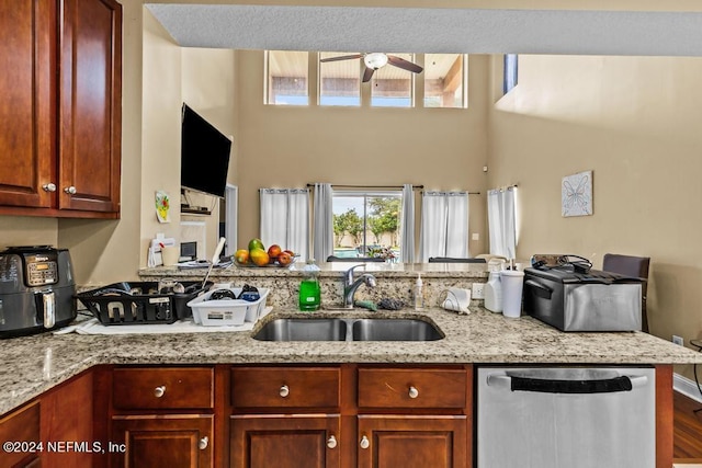 kitchen featuring hardwood / wood-style flooring, light stone counters, sink, ceiling fan, and stainless steel dishwasher