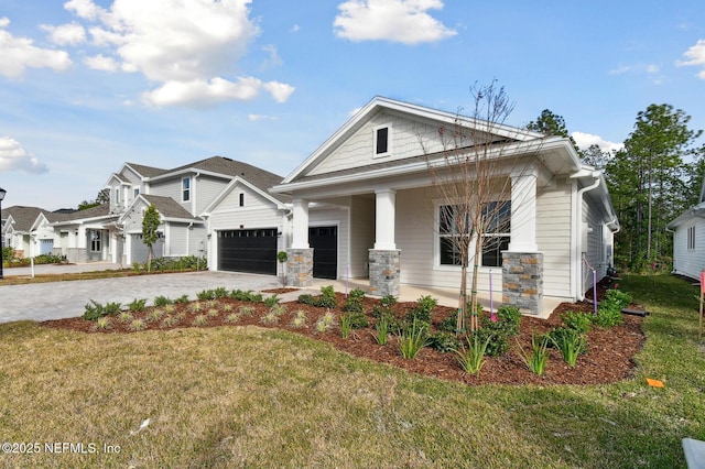 view of front of property featuring a garage, covered porch, and a front lawn