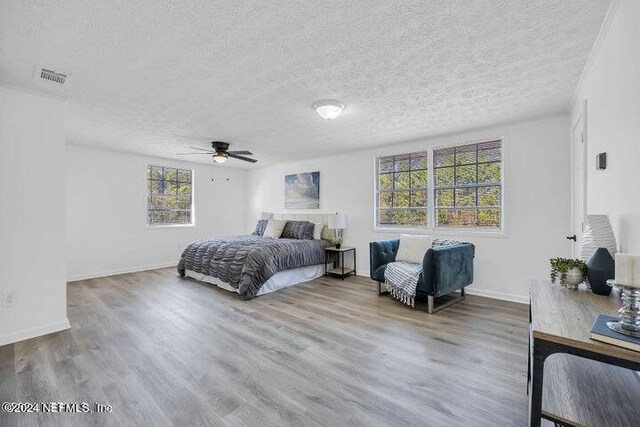 bedroom featuring hardwood / wood-style flooring, a textured ceiling, and ceiling fan