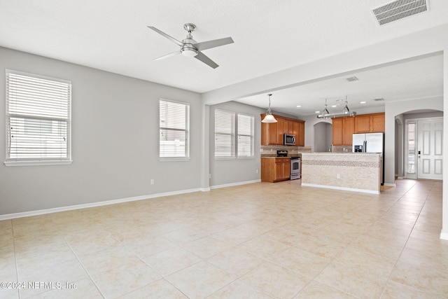 unfurnished living room with light tile patterned flooring and ceiling fan