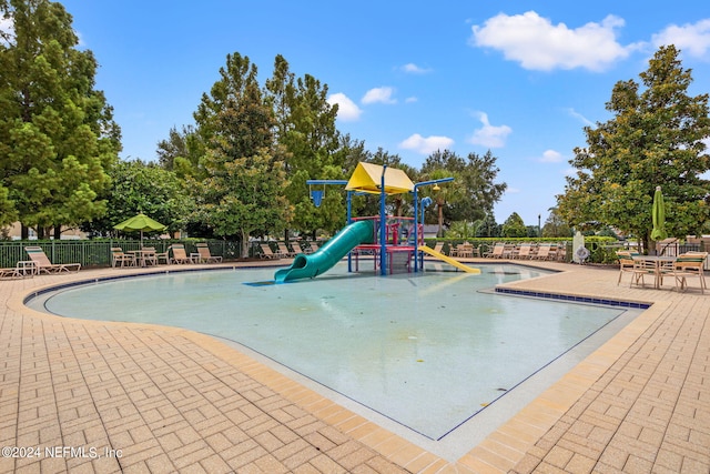 view of play area with a patio and a community pool