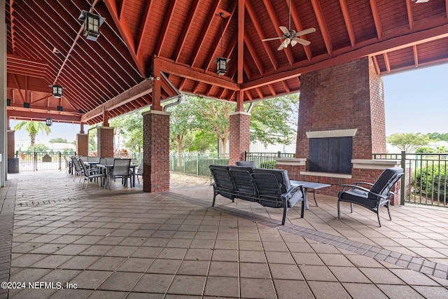 view of patio / terrace with an outdoor living space with a fireplace, a gazebo, and ceiling fan