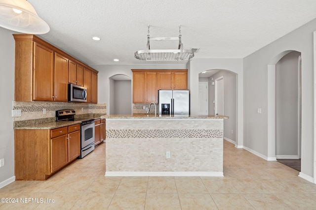 kitchen featuring decorative backsplash, appliances with stainless steel finishes, and light tile patterned floors