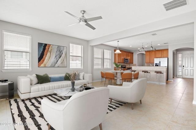 tiled living room with ceiling fan