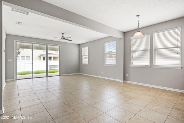 tiled empty room with a textured ceiling and ceiling fan