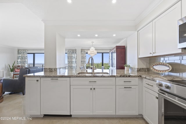 kitchen with electric stove, white cabinets, light stone counters, sink, and crown molding