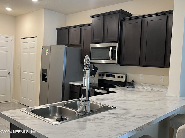 kitchen featuring kitchen peninsula, stainless steel appliances, and light tile patterned floors