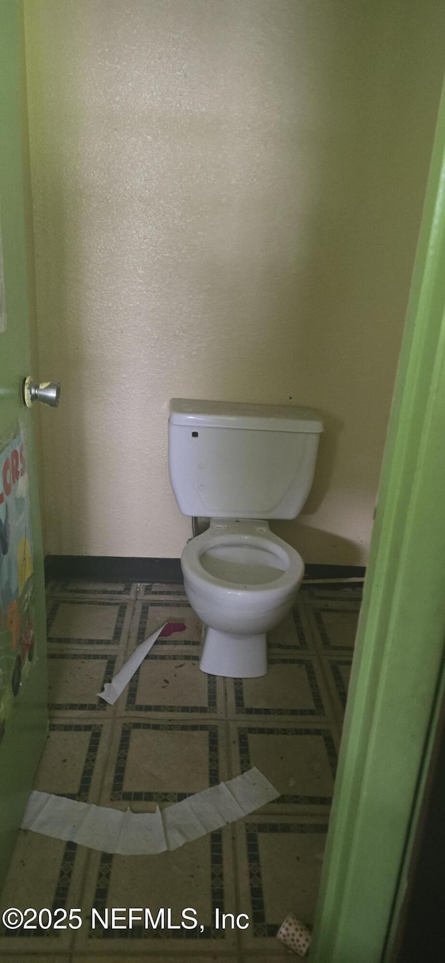 bathroom with toilet and tile patterned flooring