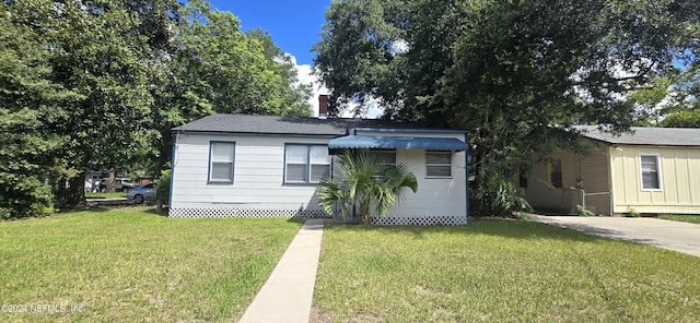 view of front facade featuring a chimney and a front yard