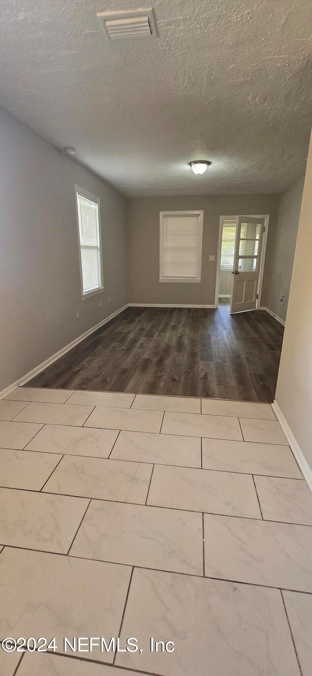 spare room with wood-type flooring and a textured ceiling