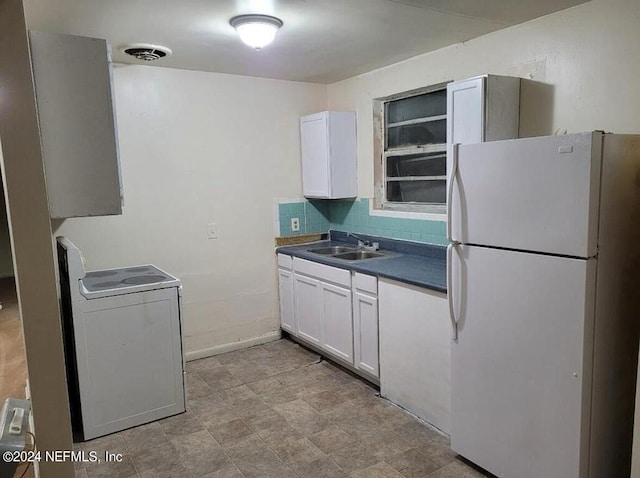 1479 8th St W, Jacksonville, FL 32209 - kitchen featuring freestanding refrigerator, white cabinets, washer / dryer, and a sink