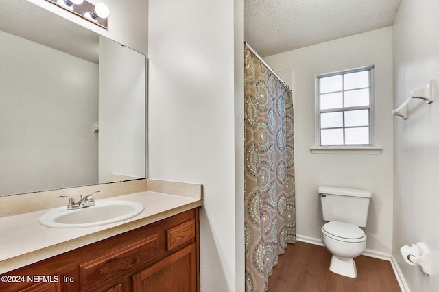 bathroom with vanity, a textured ceiling, toilet, a shower with shower curtain, and hardwood / wood-style floors