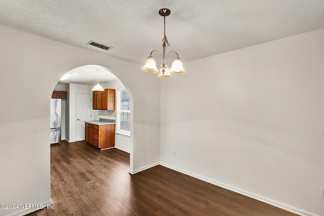 interior space featuring a textured ceiling, dark hardwood / wood-style flooring, and a chandelier