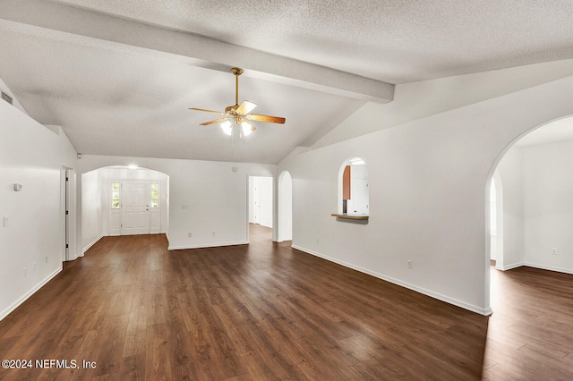 unfurnished living room with lofted ceiling with beams, a textured ceiling, ceiling fan, and dark hardwood / wood-style flooring