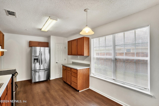 kitchen featuring appliances with stainless steel finishes, a textured ceiling, dark hardwood / wood-style floors, and decorative light fixtures