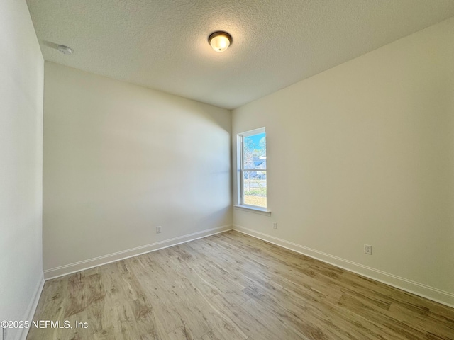 unfurnished room with light hardwood / wood-style floors and a textured ceiling