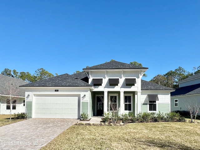 view of front of home with a garage and a front lawn