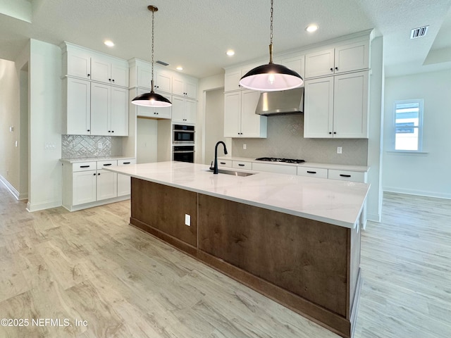 kitchen with pendant lighting, sink, white cabinetry, and gas stovetop