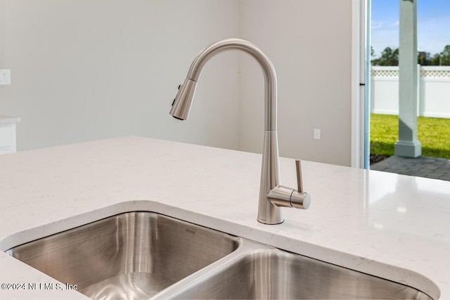 interior details featuring light stone counters and sink