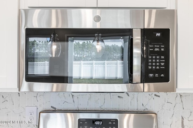 details with decorative backsplash and white cabinets