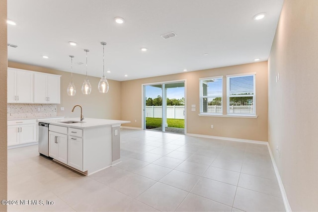 kitchen featuring sink, white cabinetry, hanging light fixtures, stainless steel dishwasher, and a kitchen island with sink