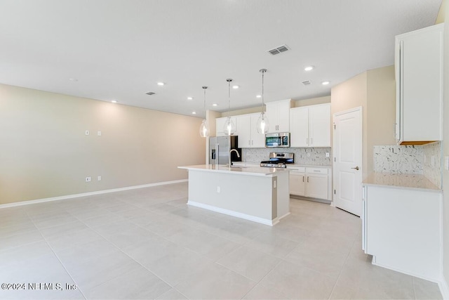 kitchen with pendant lighting, white cabinetry, stainless steel appliances, an island with sink, and decorative backsplash