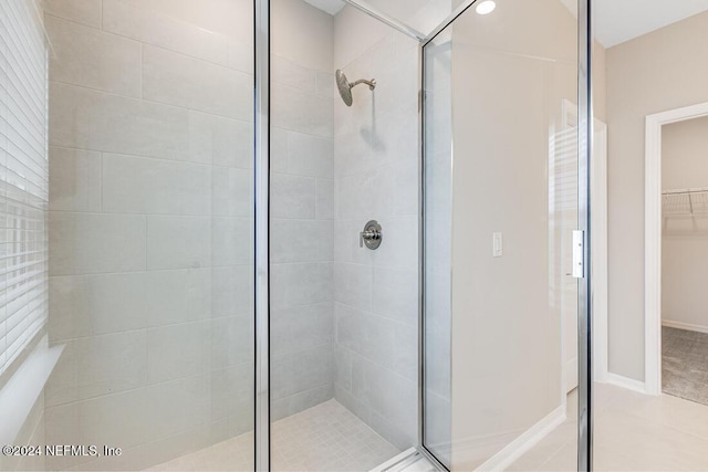 bathroom with a shower with shower door and tile patterned flooring