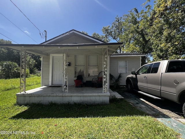 exterior space with a front lawn, a porch, and a carport