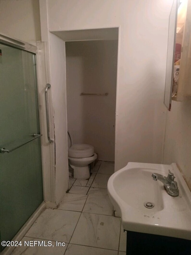 full bath featuring toilet, marble finish floor, a shower stall, and vanity