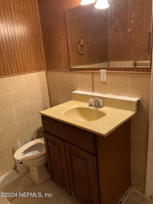 bathroom featuring tile patterned floors, tile walls, toilet, and vanity