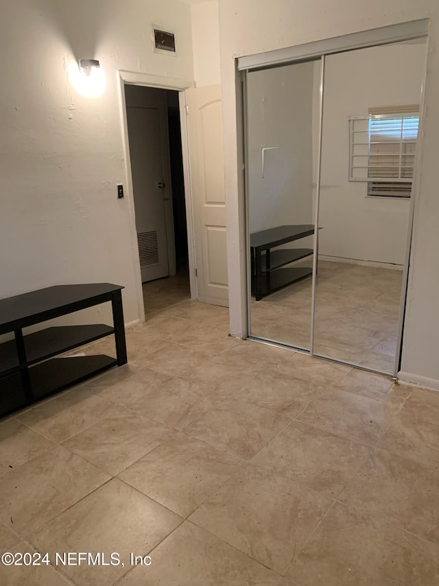 unfurnished bedroom featuring a closet and visible vents