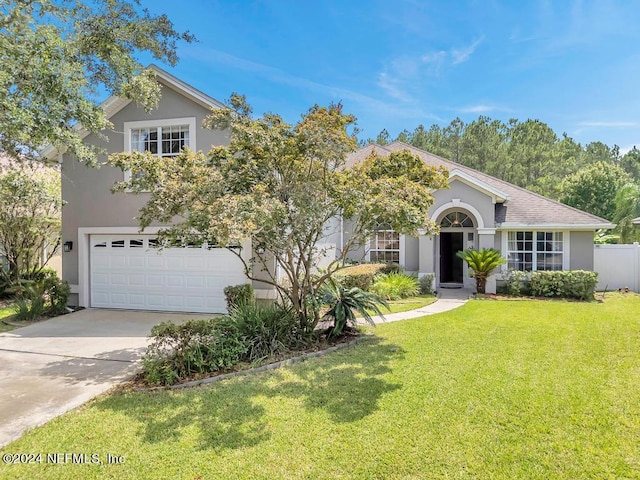 view of front of house with a garage and a front lawn