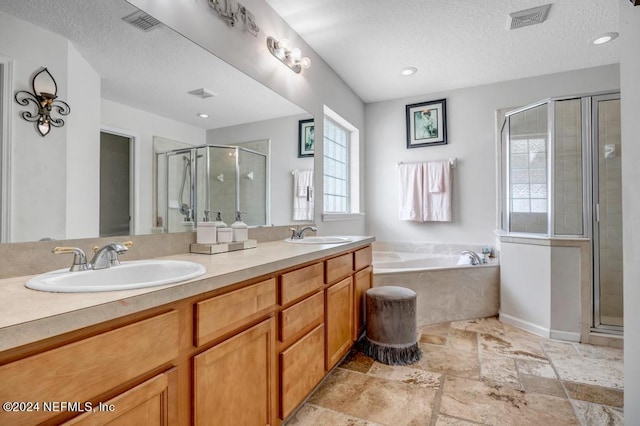 bathroom with plus walk in shower, vanity, and a textured ceiling