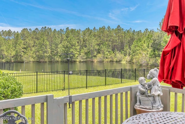 wooden terrace with a yard and a water view