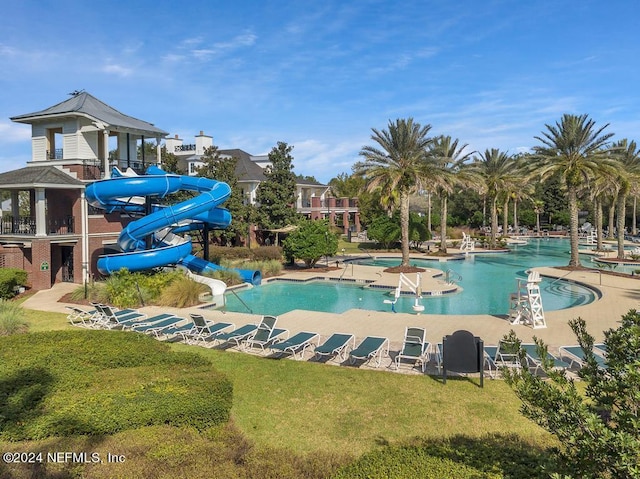 view of swimming pool with a lawn and a water slide