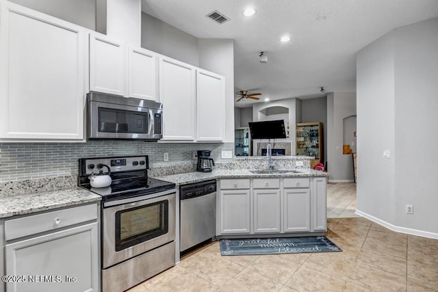 kitchen with sink, ceiling fan, backsplash, stainless steel appliances, and white cabinets