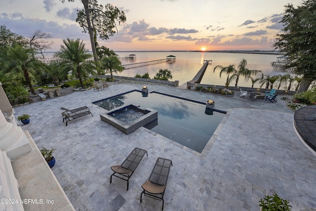 view of pool featuring a water view, an outdoor fire pit, and a patio