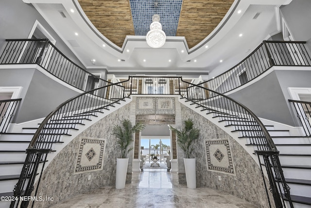 interior space with recessed lighting, marble finish floor, crown molding, and a towering ceiling