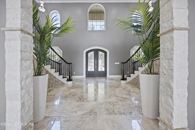 entrance foyer with french doors, marble finish floor, and stairs