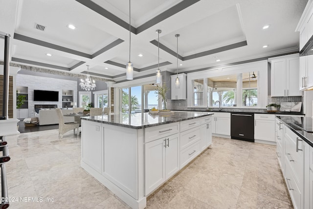 kitchen featuring open floor plan, dark stone counters, decorative light fixtures, and white cabinetry